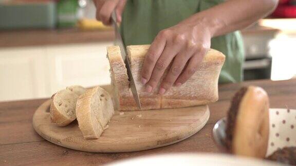 在厨房里用菜刀切面包的妇女