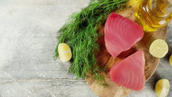 生金枪鱼排放在切菜板上加柠檬和莳萝