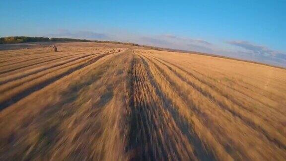 FPV无人机在秋天飞过一片麦田干草堆高速