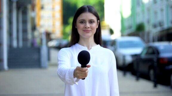 女记者提着话筒上街采访每日新闻