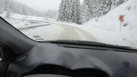 汽车POV在积雪覆盖的路上行驶先下起了雪