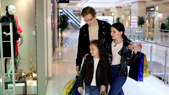 时尚家庭带着孩子在现代购物中心购物
