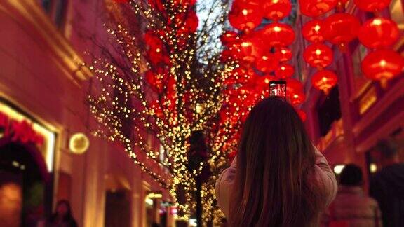 年轻女子在拍红灯笼中国新年红纸灯笼装饰在香港城市