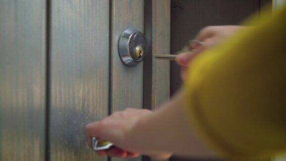女人用钥匙打开大门使用钥匙和锁门的人员房地产安全概念
