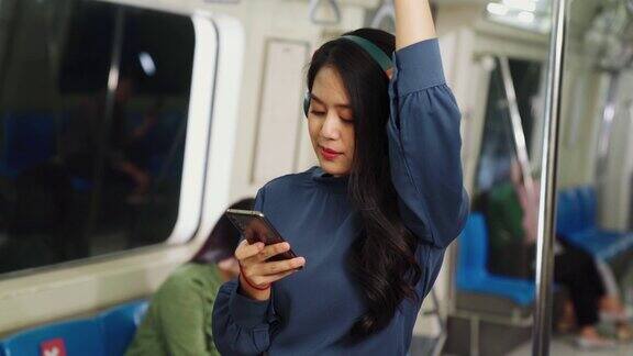 年轻女子在公共火车上使用手机