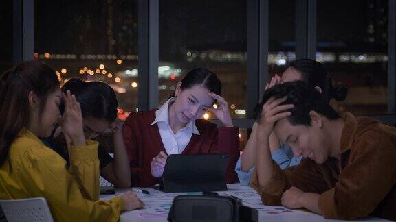 亚洲女性领导者和uxui设计师晚上在现代办公室严肃地讨论手机应用界面线框设计的截止日期工作到很晚Creativedigitaldevelopmentagency