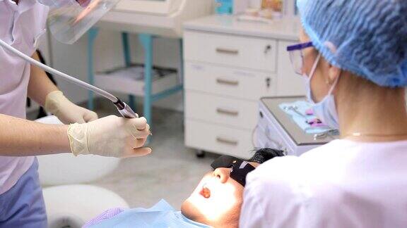 牙科医生正在用牙科设备或器械进行牙齿美白或其他口腔手术