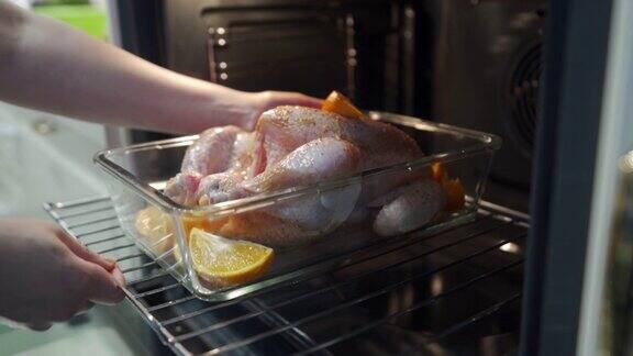 女人把整只鸡放进现代厨房的烤箱里做烤鸡