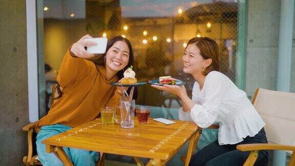 女性朋友喜欢在咖啡厅吃甜食在社交媒体上分享她们的时间