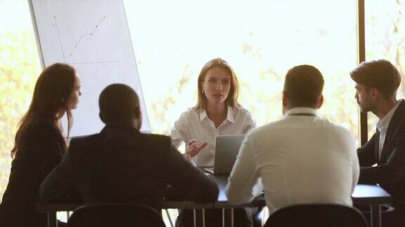 在小组办公室会议上女教练坐在桌边讲话