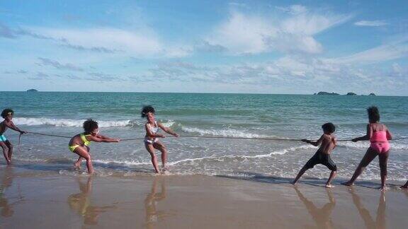 一群非洲孩子在沙滩上玩拔河游戏