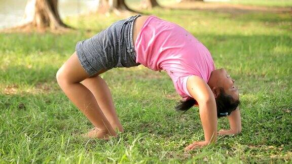 年轻的亚洲胖女孩在公园里练瑜伽