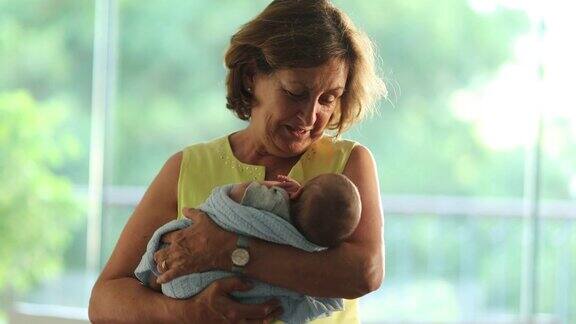 快乐的祖母平静地抱着刚出生的婴儿