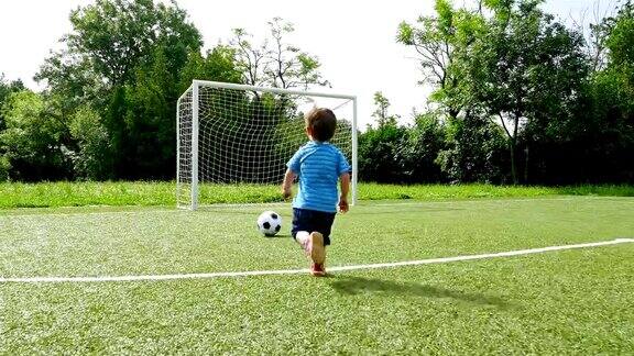 一个小男孩在足球场上进球的跟踪摄像机