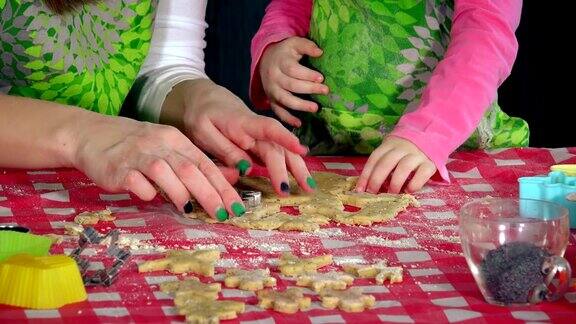 小女孩和成年妇女用手制作金属形状的饼干