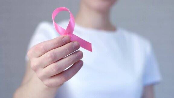 女性手握粉色乳腺癌意识丝带-乳腺癌意识理念
