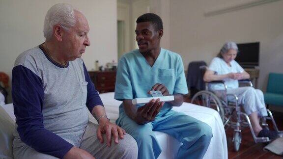 黑人男性看护者与年长的男性病人交谈