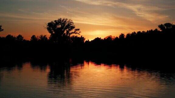 美丽的日落在森林附近的湖间隔拍摄