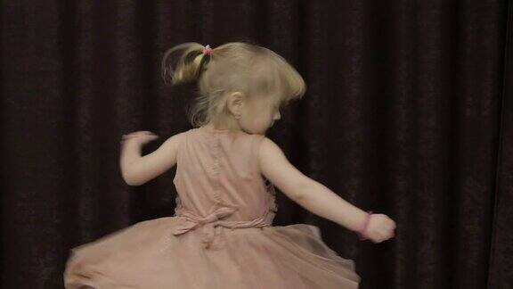 快乐的三岁小女孩做鬼脸跳舞可爱的金发的孩子棕色的眼睛可爱的女孩微笑漂亮的小孩3-4岁的金发女孩
