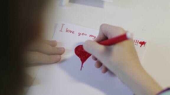 可爱的孩子在一张白纸上画了一颗红心