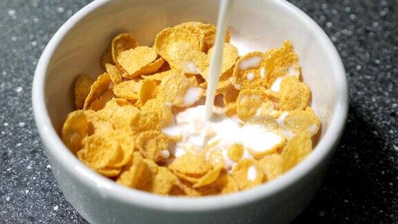 在碗中倒入牛奶和干玉米片准备早餐