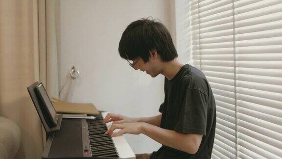 小男孩一边笑一边弹电子钢琴