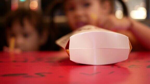 快乐的亚洲小女孩和她的妹妹在餐厅吃薯条保健和食品理念