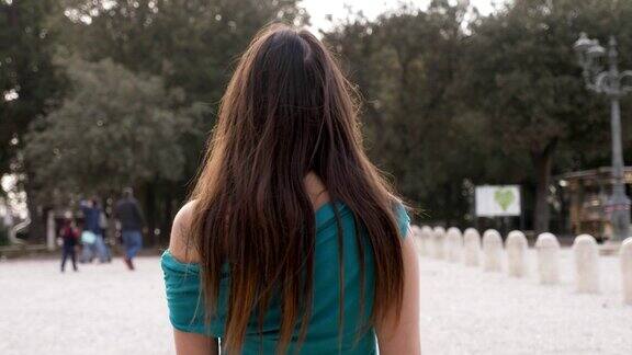 孤独悲伤的黑发女人独自走在公园里-慢镜头-背影
