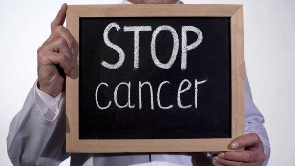 在医生手中的黑板上停止癌症文字疾病治疗创新