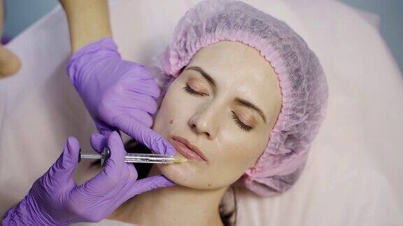 一位戴着手套的美容师正在给一位年轻女性的上下嘴唇注射肉毒杆菌