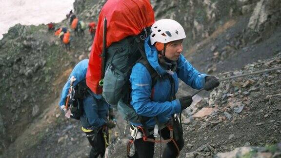 爬山的人会爬到山顶用一个带保护绳的锁扣固定在绳子上