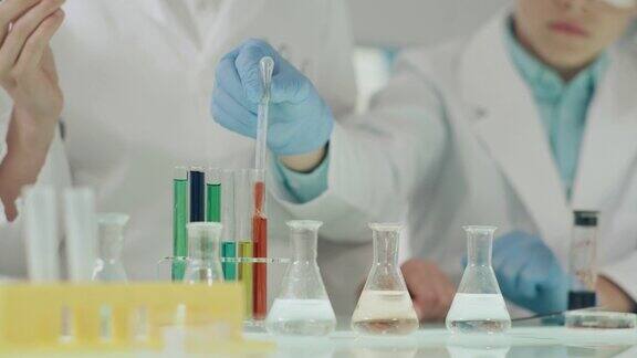 孩子们在做科学实验实验室内部用移液管灌注多种颜色的液体近距离接触
