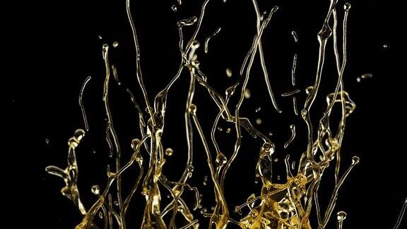 近距离油飞溅和流动隔离在黑色背景慢动作拍摄的飞溅金色液体在黑暗的背景流动滴有机黄金油彩色喷溅液体油hdr4k概念