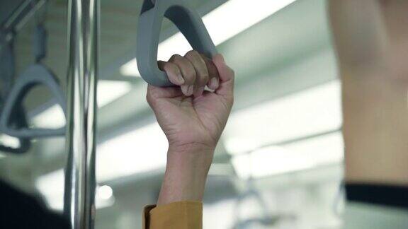 在公共交通工具中在地铁中握住扶手的手