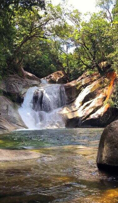 淡水瀑布镇一个岩石瀑布进入一个晶莹剔透的池下面被茂密的雨林包围