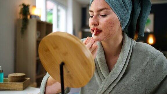 洗完澡脸上有白癜风和粉刺的女人涂上唇彩