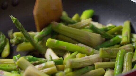 绿芦笋茎在一个大煎锅里煎特写镜头有选择性的重点