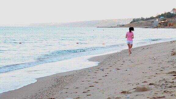女孩在海边的沙滩上慢跑