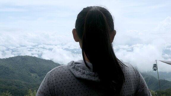 后视图亚洲年轻女子享受与雾的自然山峰在早上
