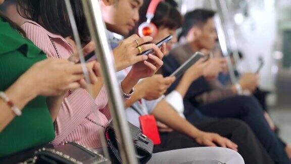 年轻人在公共地铁上使用手机