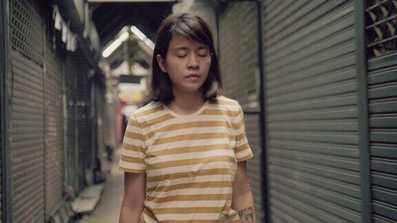悲伤的年轻亚洲女人独自走在商店里