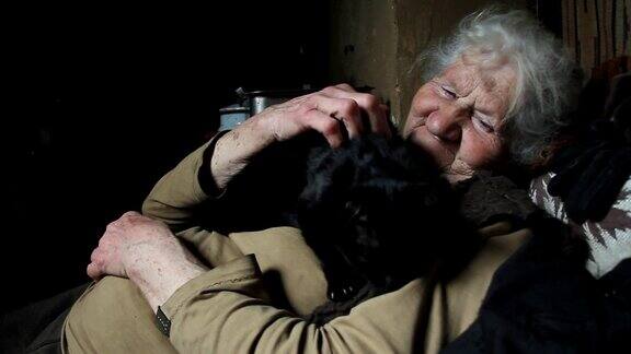 一个灰白头发的老妇人抱着她的黑猫在怀里和她玩耍微笑住在一个废弃的村庄选择性的焦点