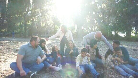 几代西班牙裔家庭在公园里坐在地上