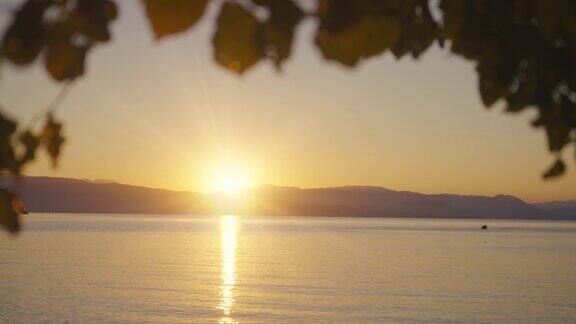 日出在海上与反射和太阳升起在山脉的背景