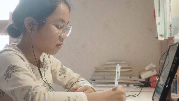 十几岁的女孩在家里学习在线视频课程