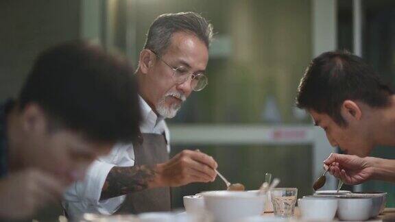 专业的亚洲华人高级男子咖啡师鉴赏家表演咖啡杯品尝咖啡杯用勺子