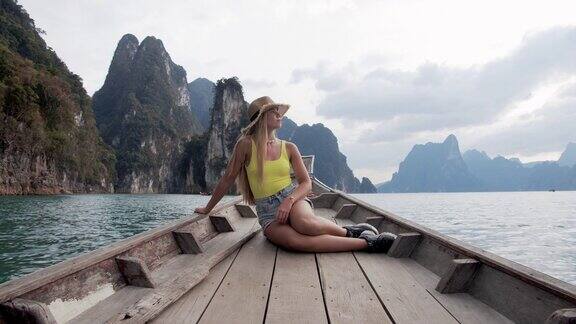 模特在泰国的湖中移动的船摆姿势