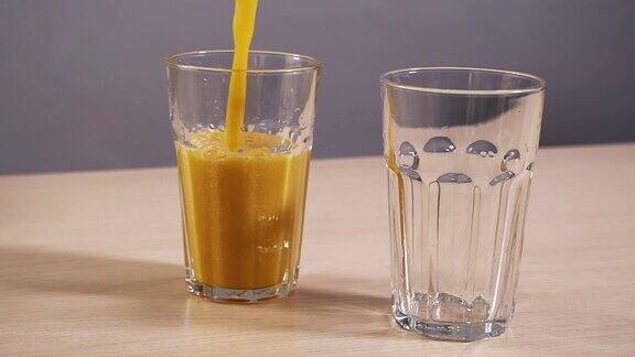 两个空杯子装满了新鲜橙汁慢动作白色背景特写