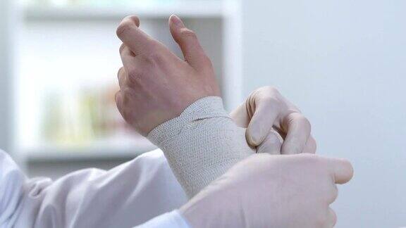 创伤学家包扎病人的手腕伸展肌肉急救课程