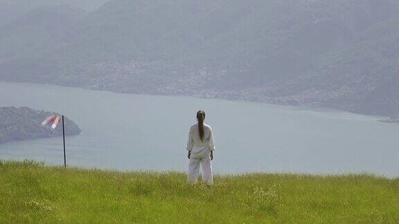 一名妇女站在后面观察山间的湖泊